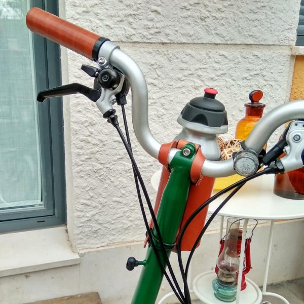 Brown bottle cage on handlebar with bicycle bottle